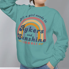 Person wearing a teal sweatshirt with a rainbow design and text against a gray background