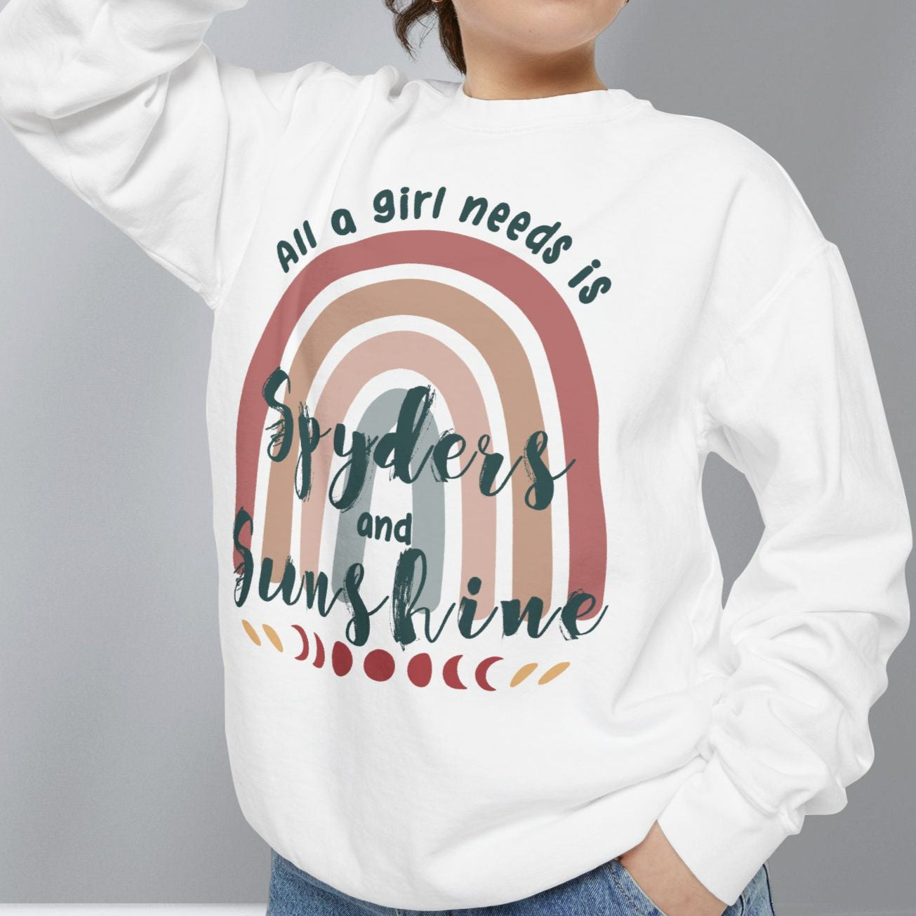 Person wearing a white sweatshirt with a rainbow design and text, standing against a plain background.