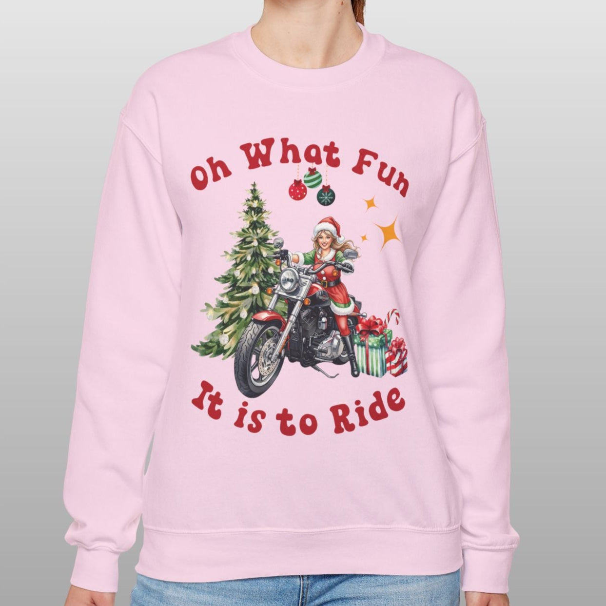 Person wearing a pink sweatshirt with Christmas-themed design and text.