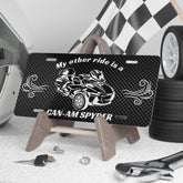 License plate with Can-Am Spyder design on a stand, surrounded by automotive items.