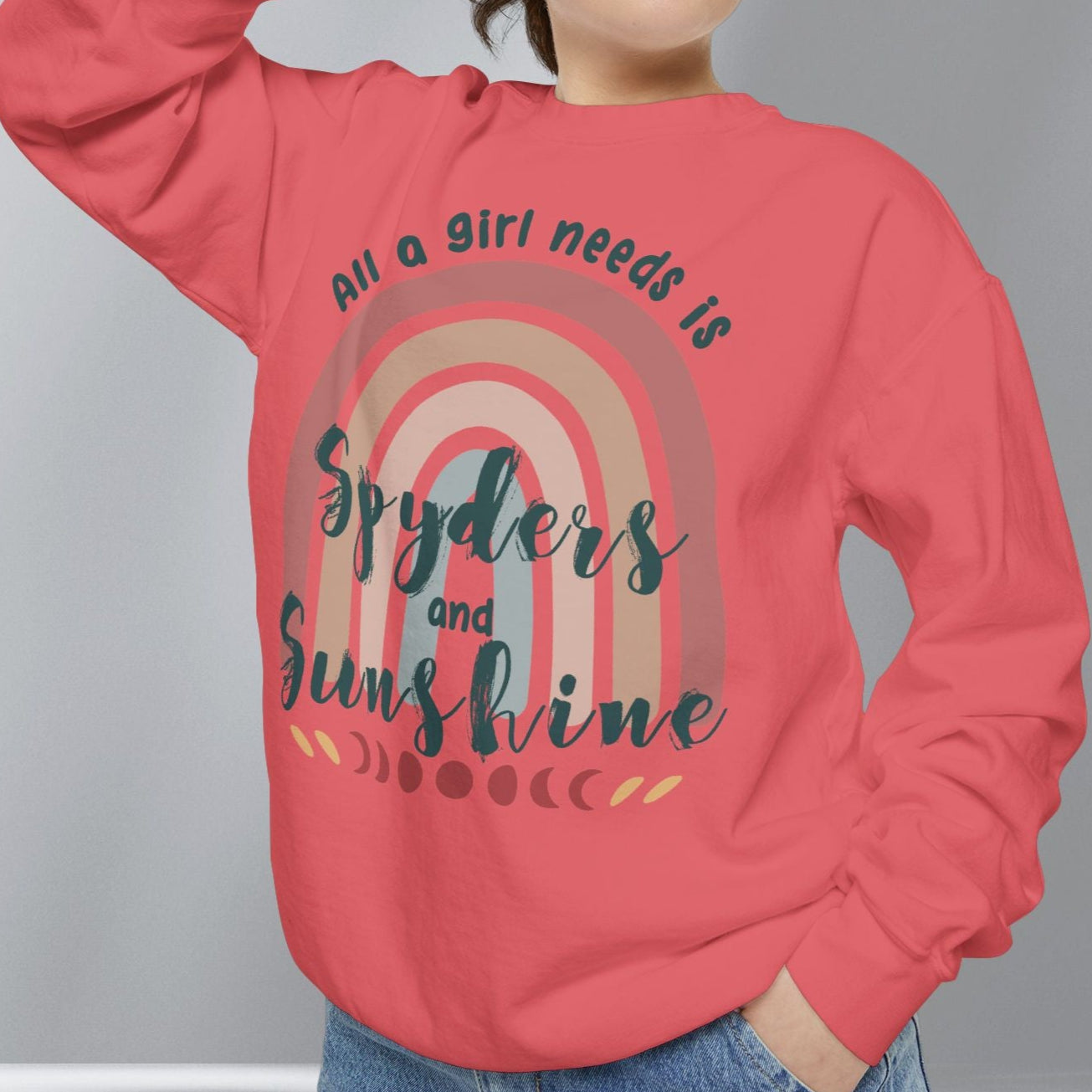 Person wearing a red sweatshirt with a rainbow design and text on a gray background