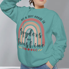 Person wearing a teal sweatshirt with a rainbow design and text, standing against a plain background.