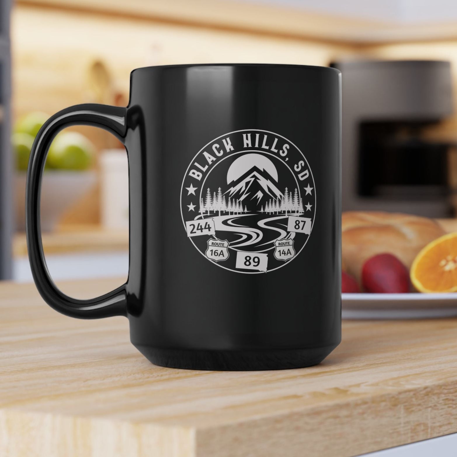 Black mug with a white graphic design on a kitchen counter