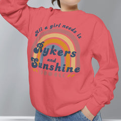 Person wearing a red sweatshirt with a rainbow design and text, standing against a plain background.