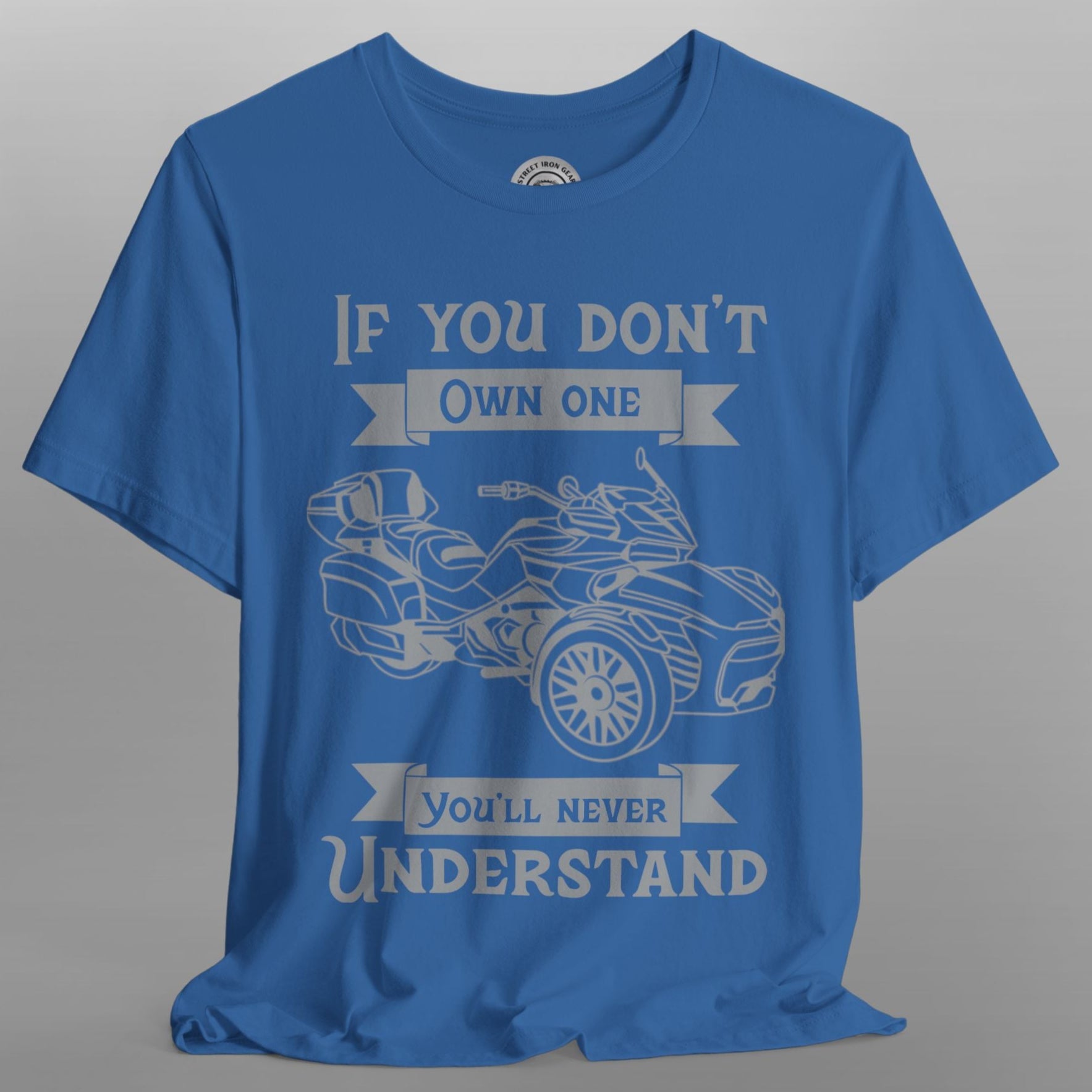 Blue t-shirt with graphic of a three-wheeled vehicle and text on a gray background