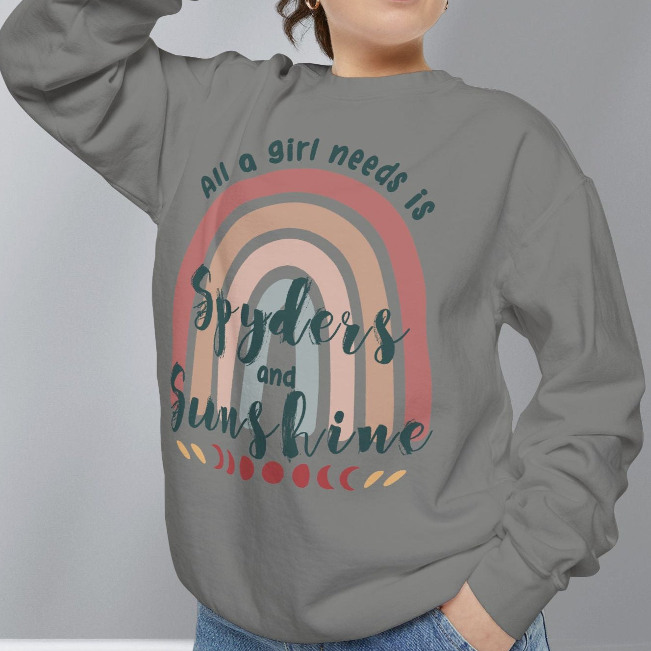 Person wearing a gray sweatshirt with a rainbow design and text on a plain background