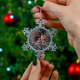 Person holding a snowflake-shaped Christmas ornament with a tree in the background