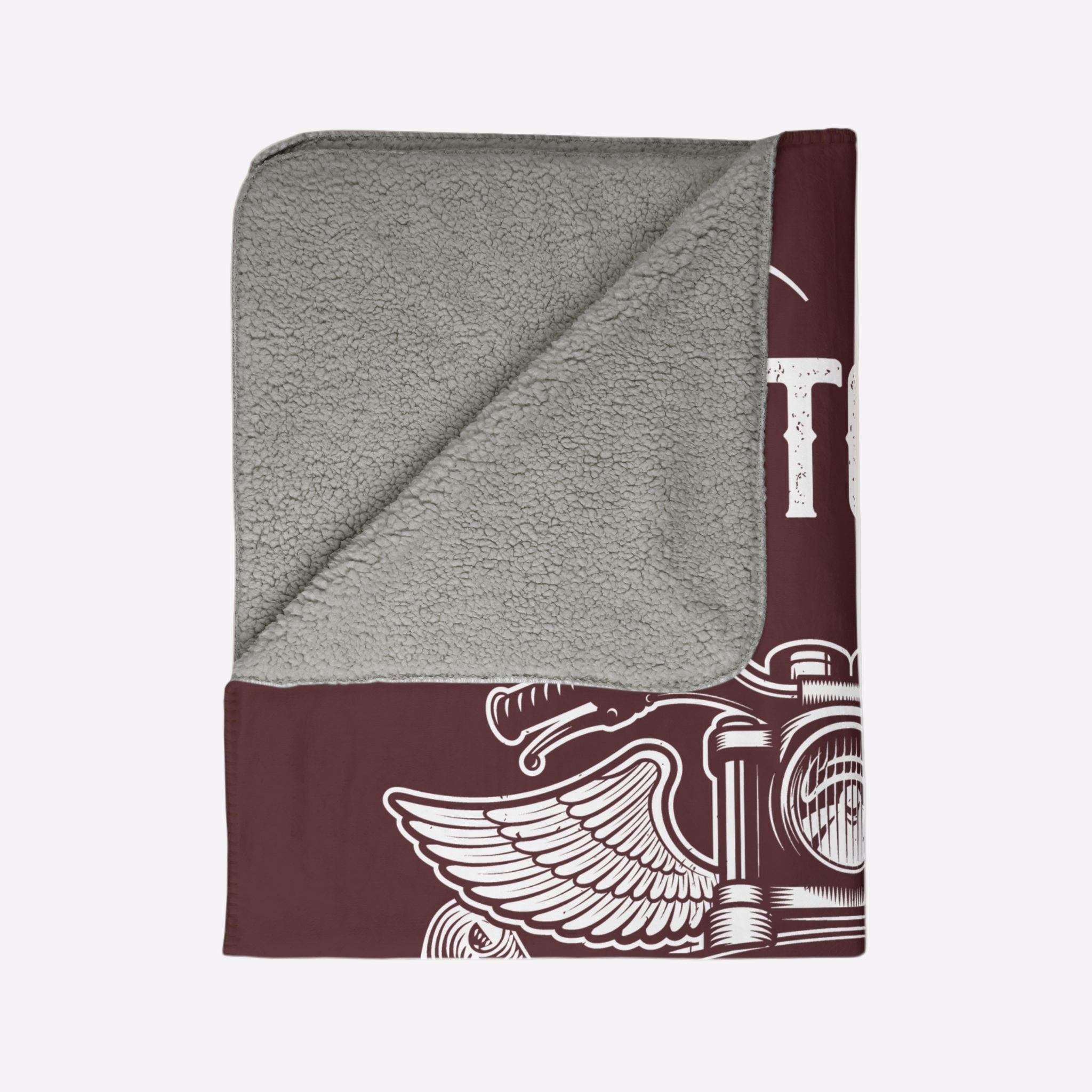 Folded gray and maroon towel with a design on a light beige background