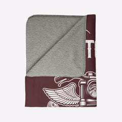 Folded gray and maroon towel with a design on a light beige background