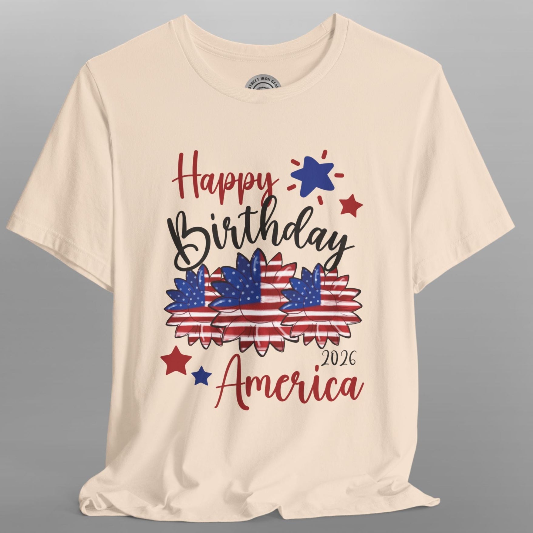 Beige t-shirt with 'Happy Birthday America 2026' text and graphics on a gray background