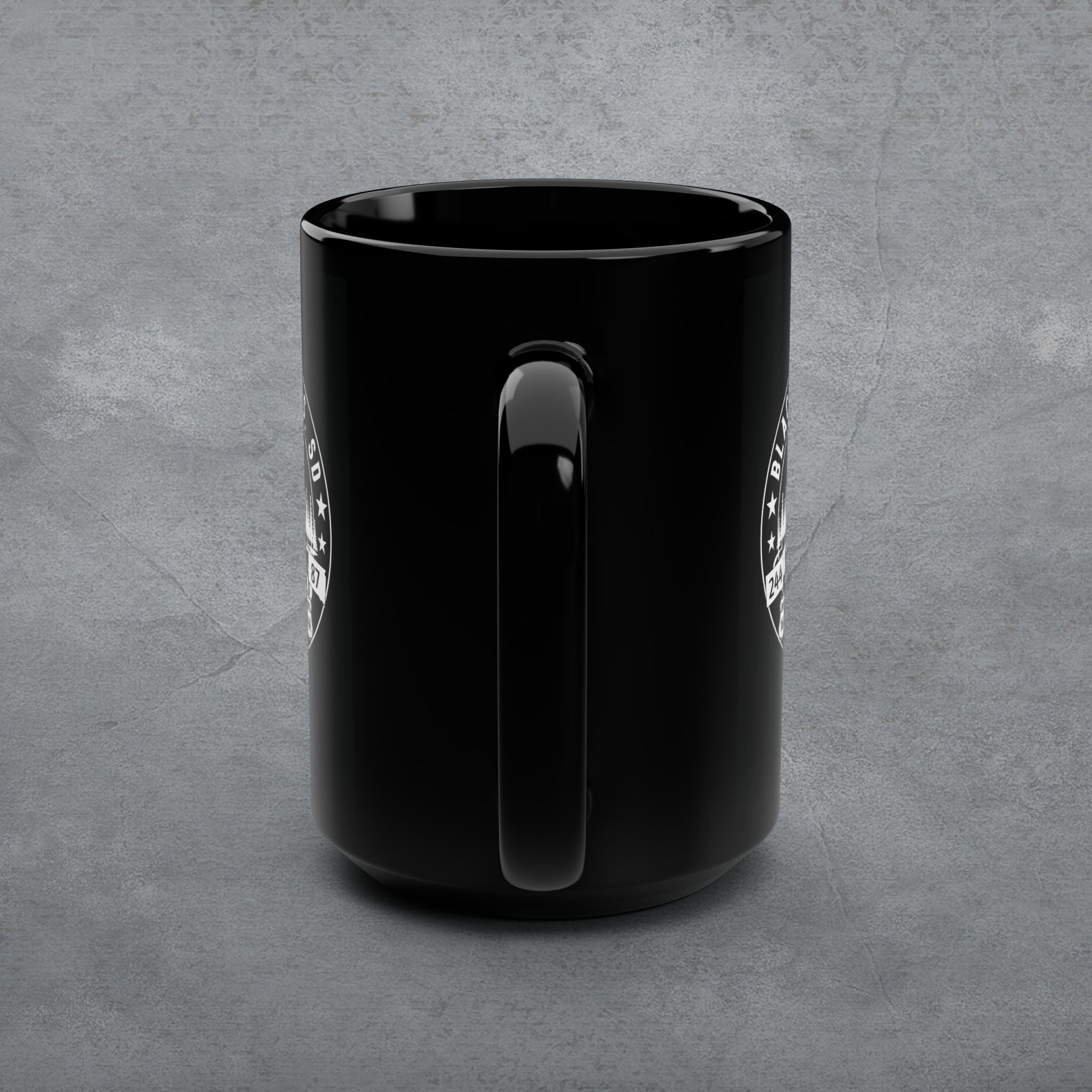 Black mug with a handle on a gray concrete background
