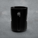 Black mug with a handle on a gray concrete background