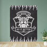A black Sherpa fleece blanket with a white motorcycle design and the text 'Bikers DO IT BETTER' printed on it, displayed on a wooden surface with a green background.