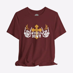 A black crew neck t-shirt with a graphic print of skeleton hands, a gold cross, and the text 'Wheels Down'.