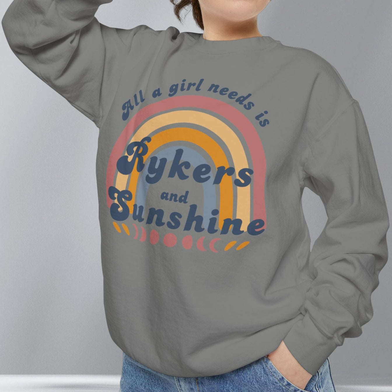 Person wearing a gray sweatshirt with a colorful graphic and text on a plain background