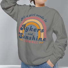 Person wearing a gray sweatshirt with a colorful graphic and text on a plain background