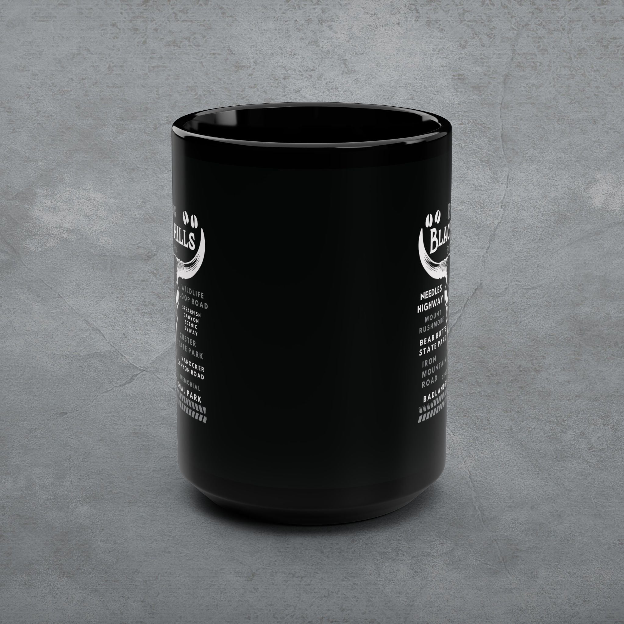 Black mug with white text on a gray concrete background