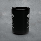 Black mug with white text on a gray concrete background
