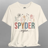 White t-shirt with colorful 'SPYDER ryder' text and floral designs on a gray background