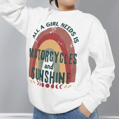 Person wearing a white sweatshirt with a graphic design and text, standing against a plain background.