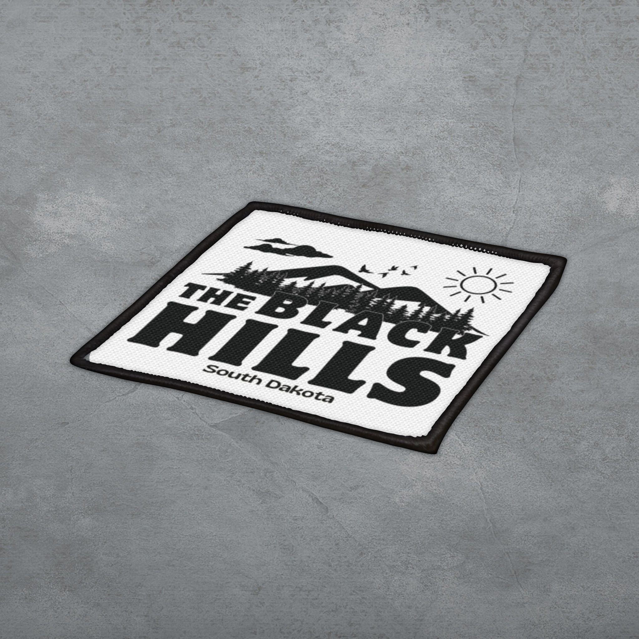 Black and white patch with 'The Black Hills South Dakota' text on a gray surface