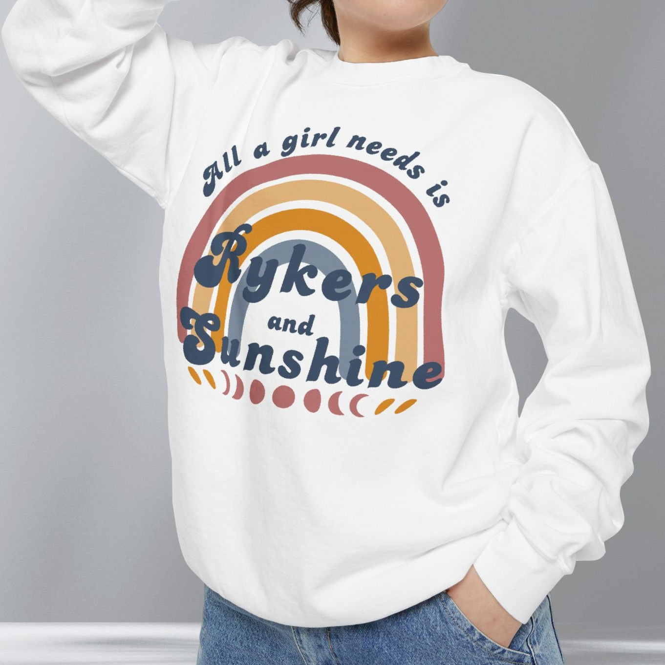 Person wearing a white sweatshirt with text and rainbow design against a gray background