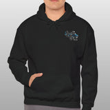 Man wearing a black hoodie with a logo on a gray background