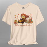 Beige t-shirt with a cartoon character and autumn-themed design on a gray background