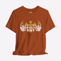 A black crew neck t-shirt with a graphic print of skeleton hands, a gold cross, and the text 'Wheels Down'.