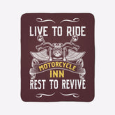 Blanket with motorcycle design and text 'Live to Ride, Motorcycle Inn, Rest to Revive' on a green wall.