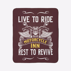 Blanket with motorcycle design and text 'Live to Ride, Motorcycle Inn, Rest to Revive' on a green wall.