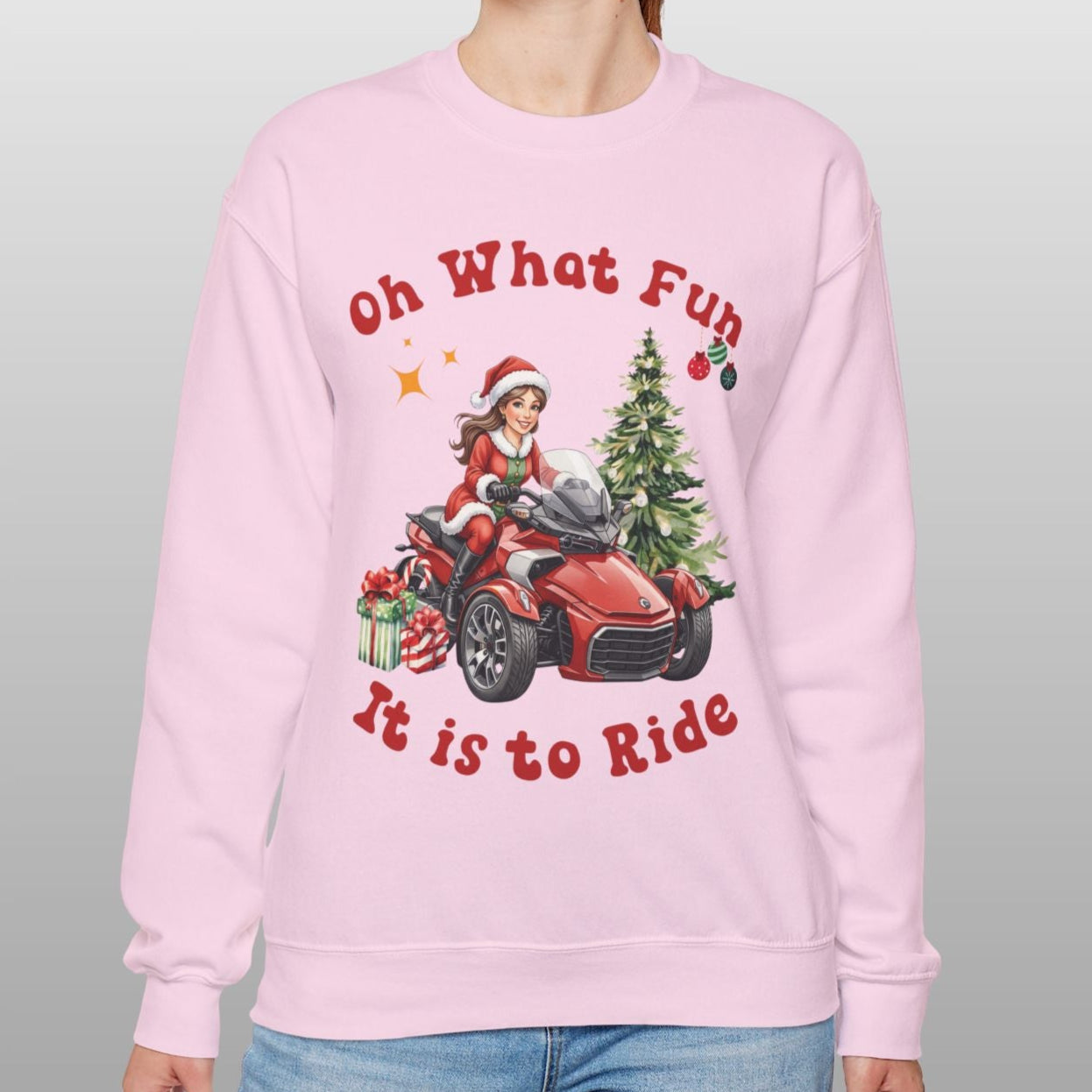 Person wearing a pink sweatshirt with Christmas-themed graphics and text.