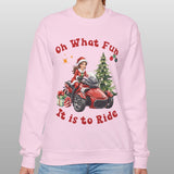 Person wearing a pink sweatshirt with Christmas-themed graphics and text.