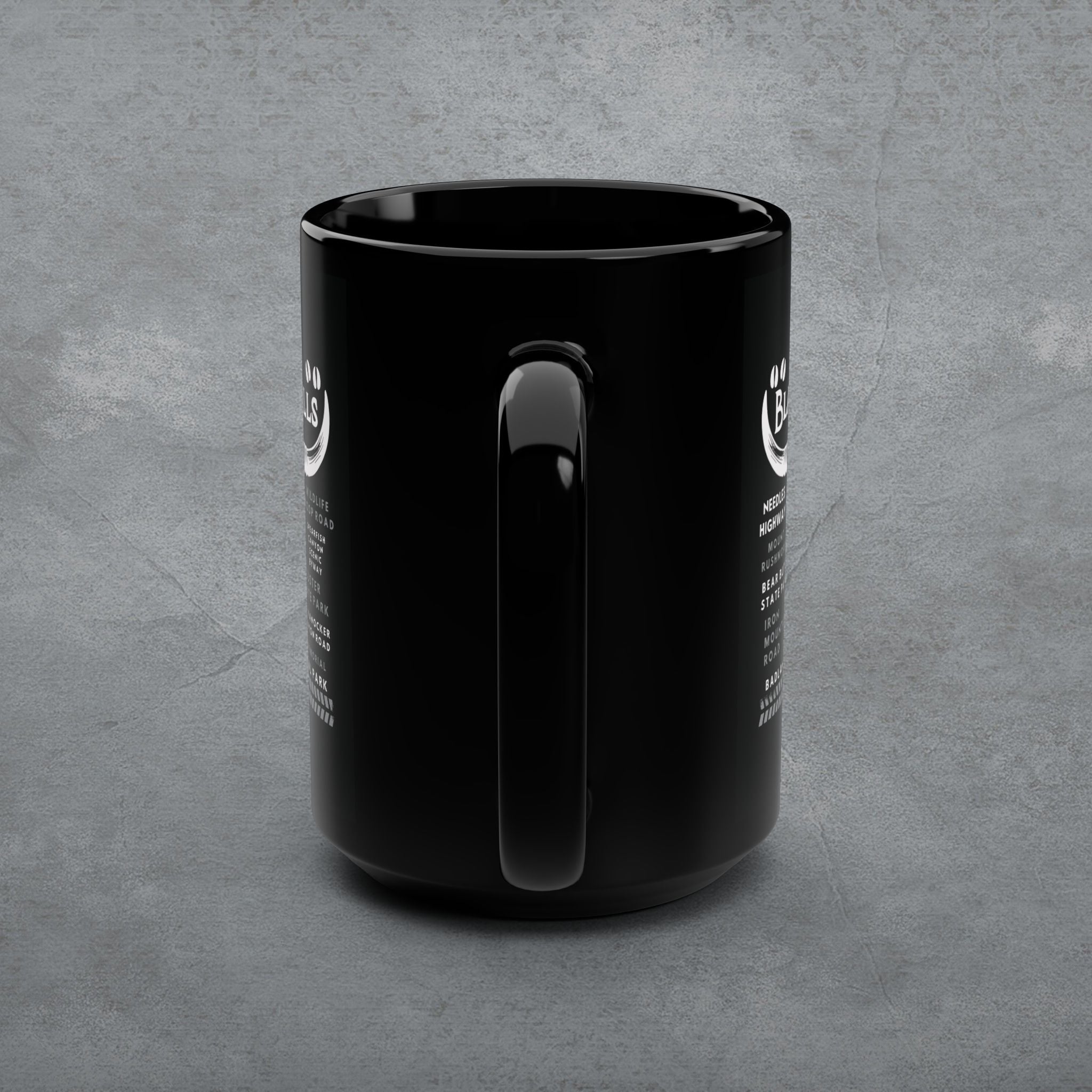 Black mug with a handle on a gray concrete background