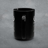 Black mug with a handle on a gray concrete background