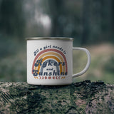 White mug with text and rainbow design on a tree stump in a forest setting