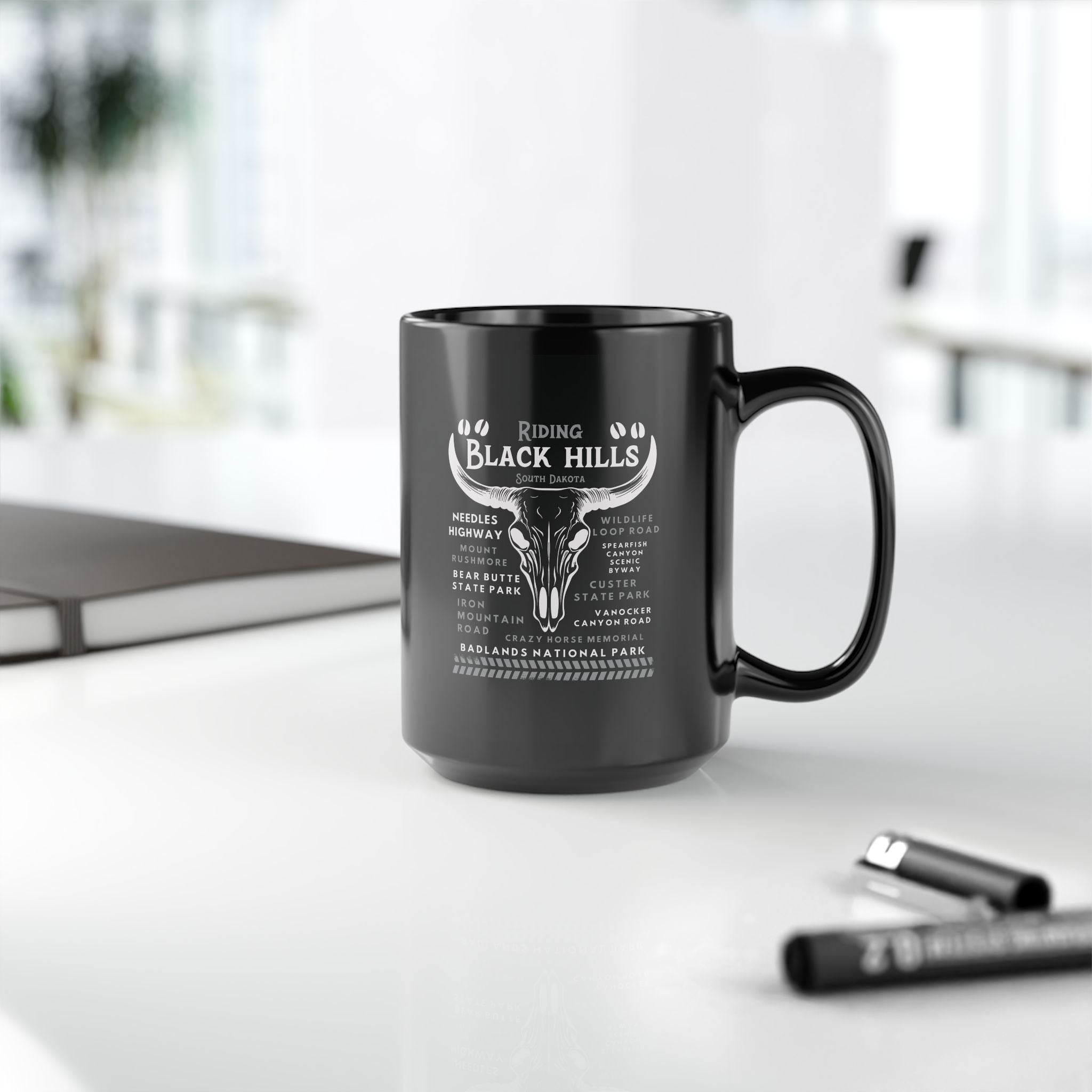 Black mug with white text and design on a white surface