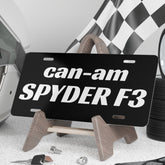 Black license plate with 'can-am SPYDER F3' text on a stand, surrounded by automotive items.