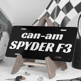 Black license plate with 'can-am SPYDER F3' text on a stand, surrounded by automotive items.