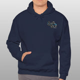 Man wearing a navy blue hoodie with a logo on a gray background