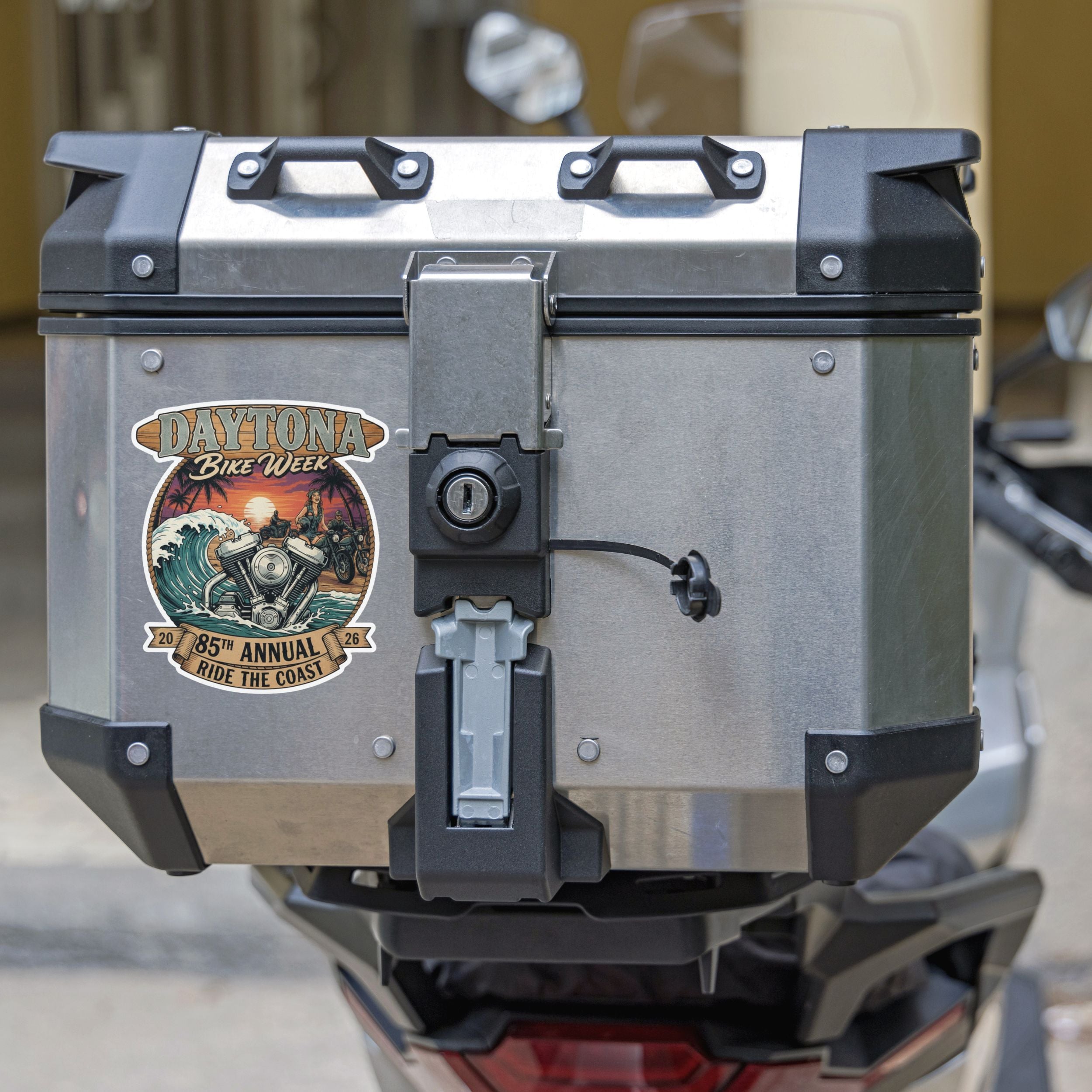Motorcycle luggage box with a Daytona Bike Week sticker on a blurred background