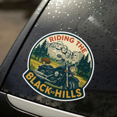 Sticker on a car window with 'Riding the Black Hills' design featuring Mount Rushmore and a motorcycle.