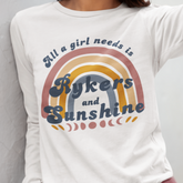 White sweatshirt with rainbow design and text 'All a girl needs is Rykers and Sunshine' on a plain background.