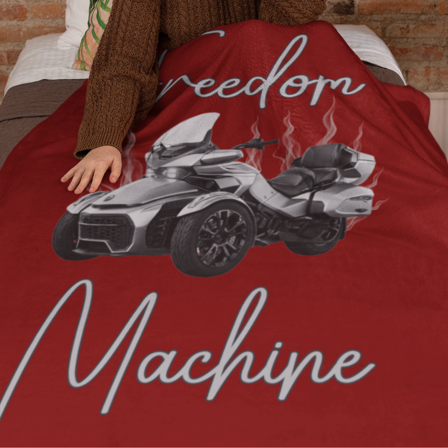 Person sitting on a bed with a red blanket featuring a graphic of a vehicle and text.