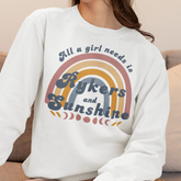 Person wearing a white sweatshirt with a colorful graphic and text.
