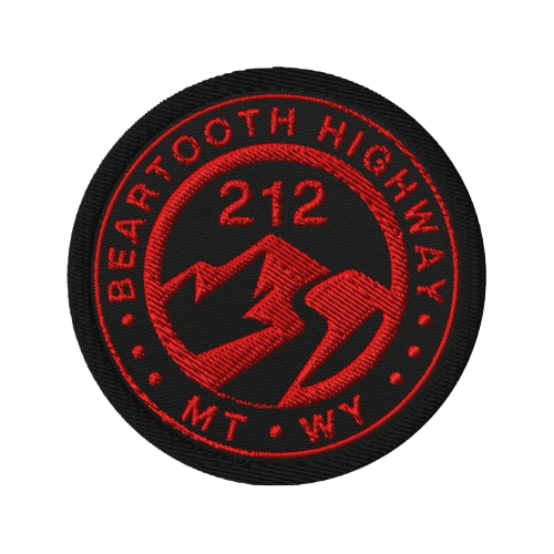 A circular embroidered patch featuring the text 'BEARTOOTH HIGHWAY' and 'MT WY' in red around a mountain and lightning bolt design, with '212' in the center, on a black background.
