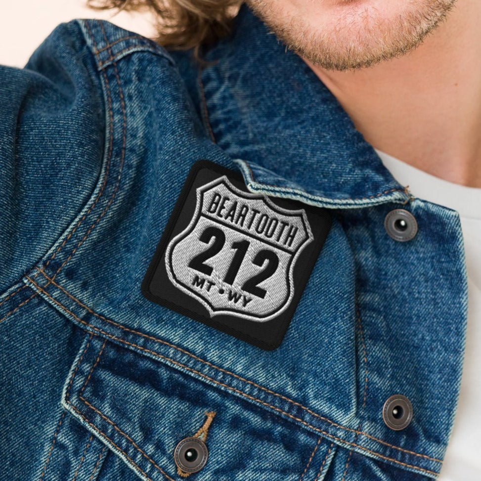 Man wearing a denim jacket with a patch on a beige background
