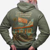 Person wearing a green hoodie with a graphic design on the back, featuring a motel and motorcycle.