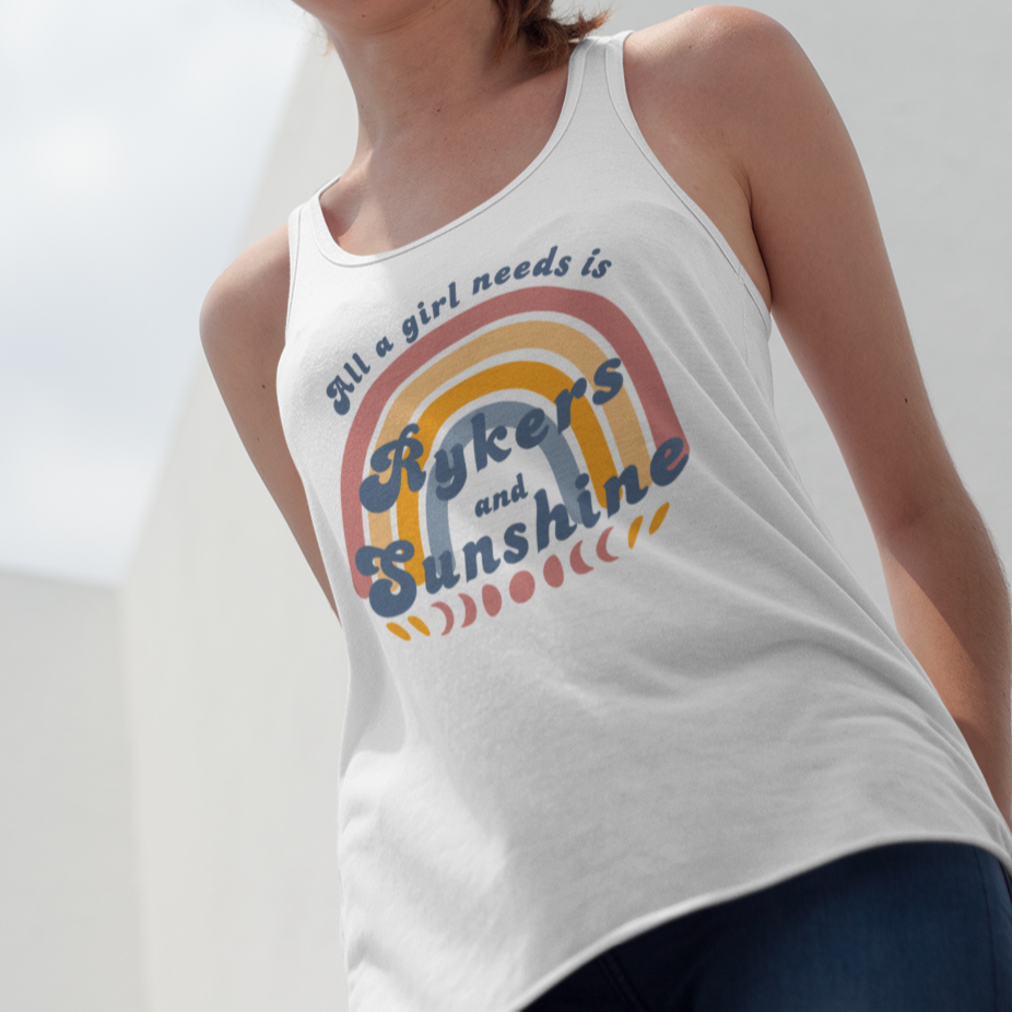 Woman wearing a white tank top with colorful text and graphics against a blue sky.