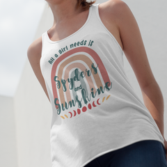 Woman wearing a white tank top with rainbow design and text, standing outdoors against a blue sky.